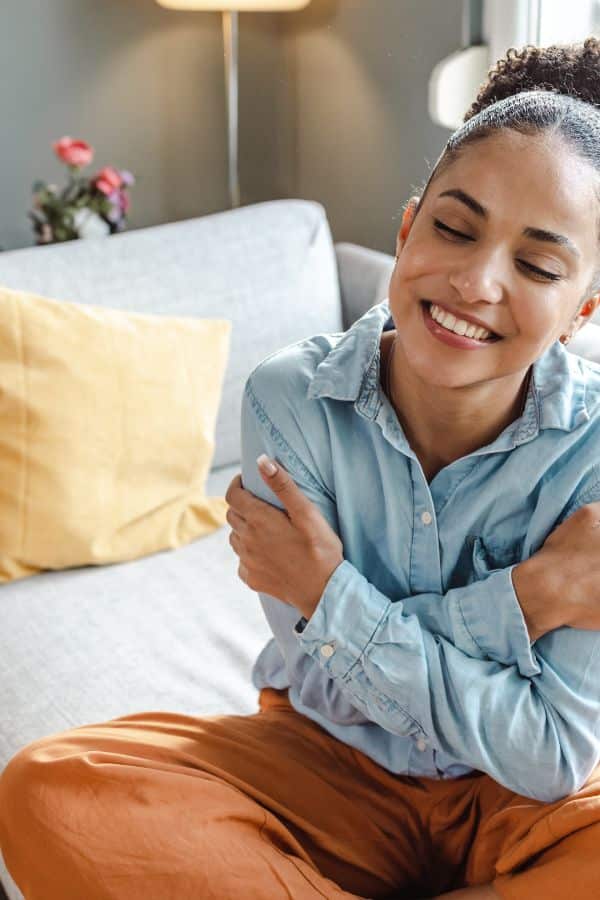 You Should Talk to Yourself Like Someone You Love! 4 closed eyed woman by a window in her bed smiling- talk to yourself like someone you love