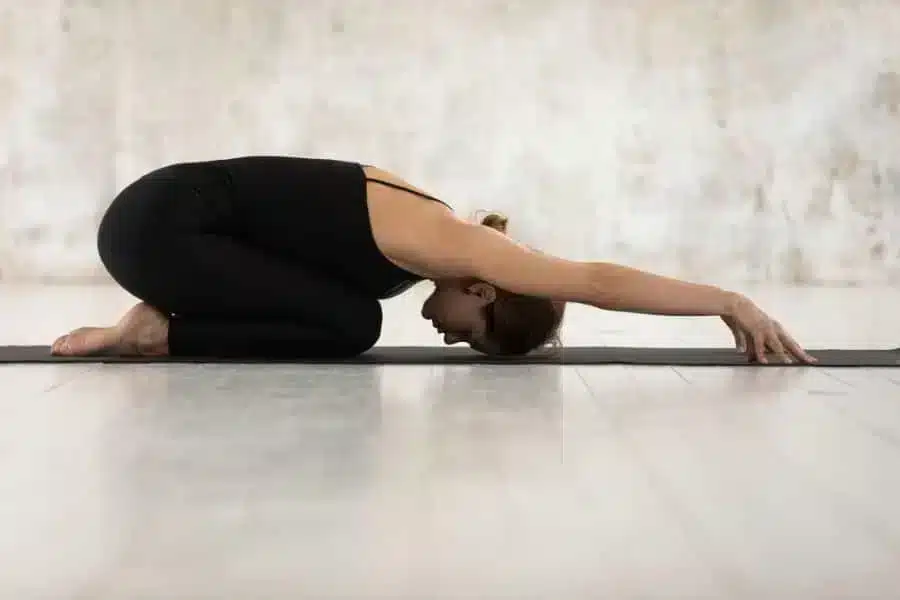 woman in restorative yoga pose- Child's Pose
