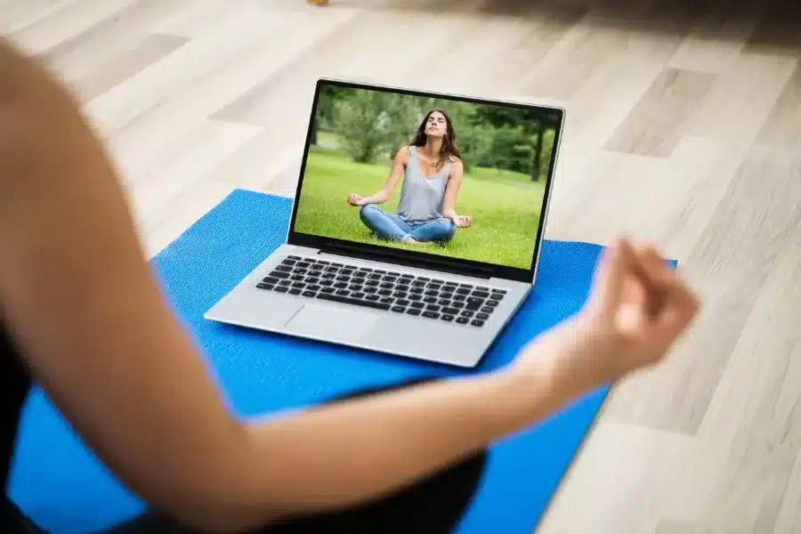 woman in following yoga and meditation online class