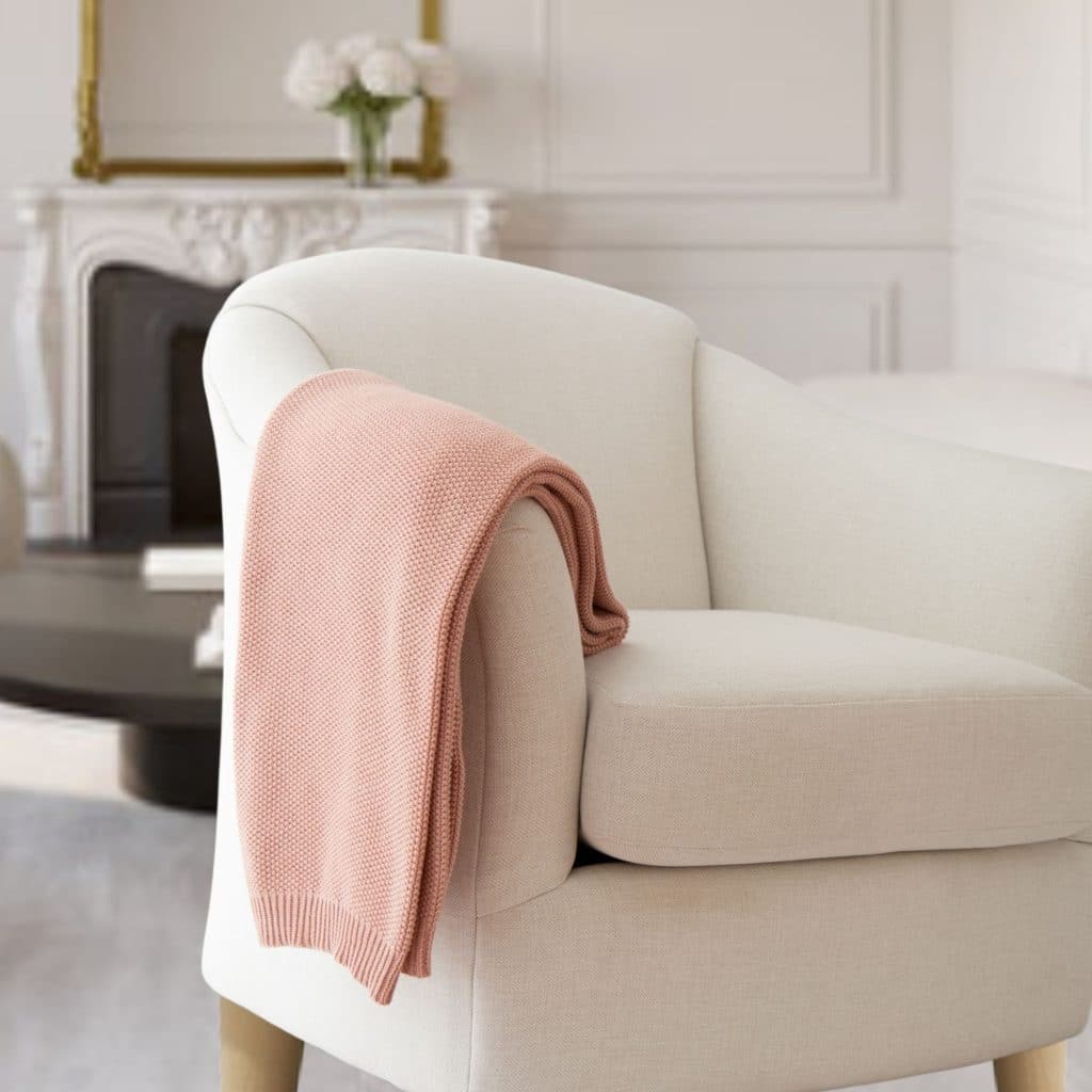 Rose colored Cotton Seed stitch Knit Throw draped on couch
