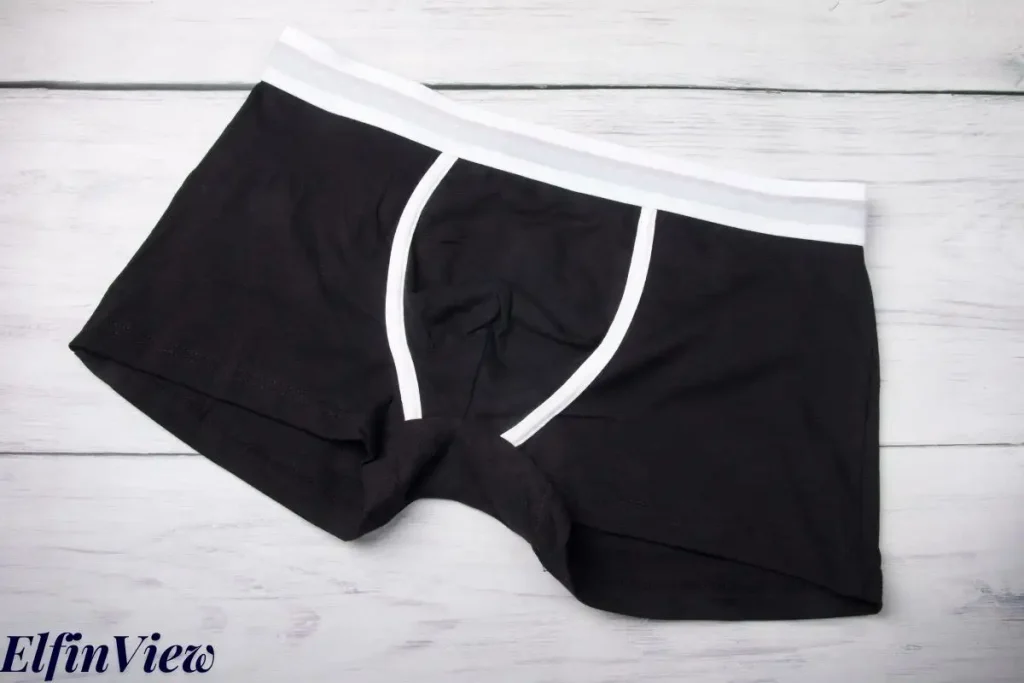 How to Choose the Right Period Underwear for You 3 A pair of black period boyshorts with white trim, laid flat on a white wooden surface, indicating a comfortable style for heavy flow days as described in the article.