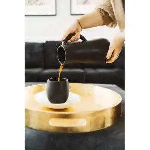 Handle less 15 oz GHARYAN Stoneware Coffee Mugs 6 Coffee being poured from a black carafe into a black GHARYAN Stoneware Coffee Mug, placed on a stylish golden tray.